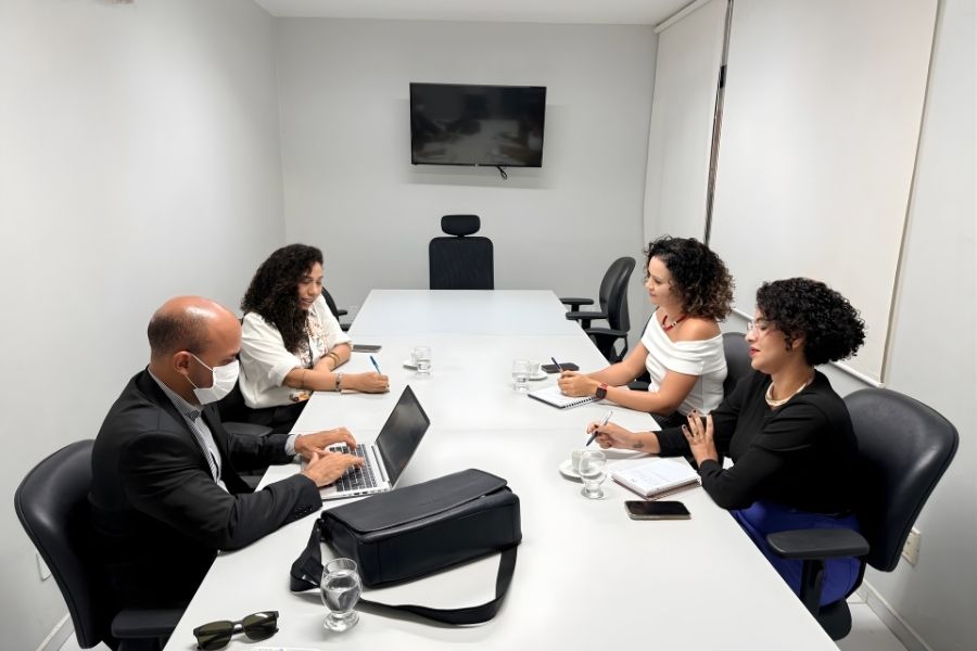 Juiz Vinicus Augusto, presidente da Comissão, reunido com servidoras  integrantes do grupo.