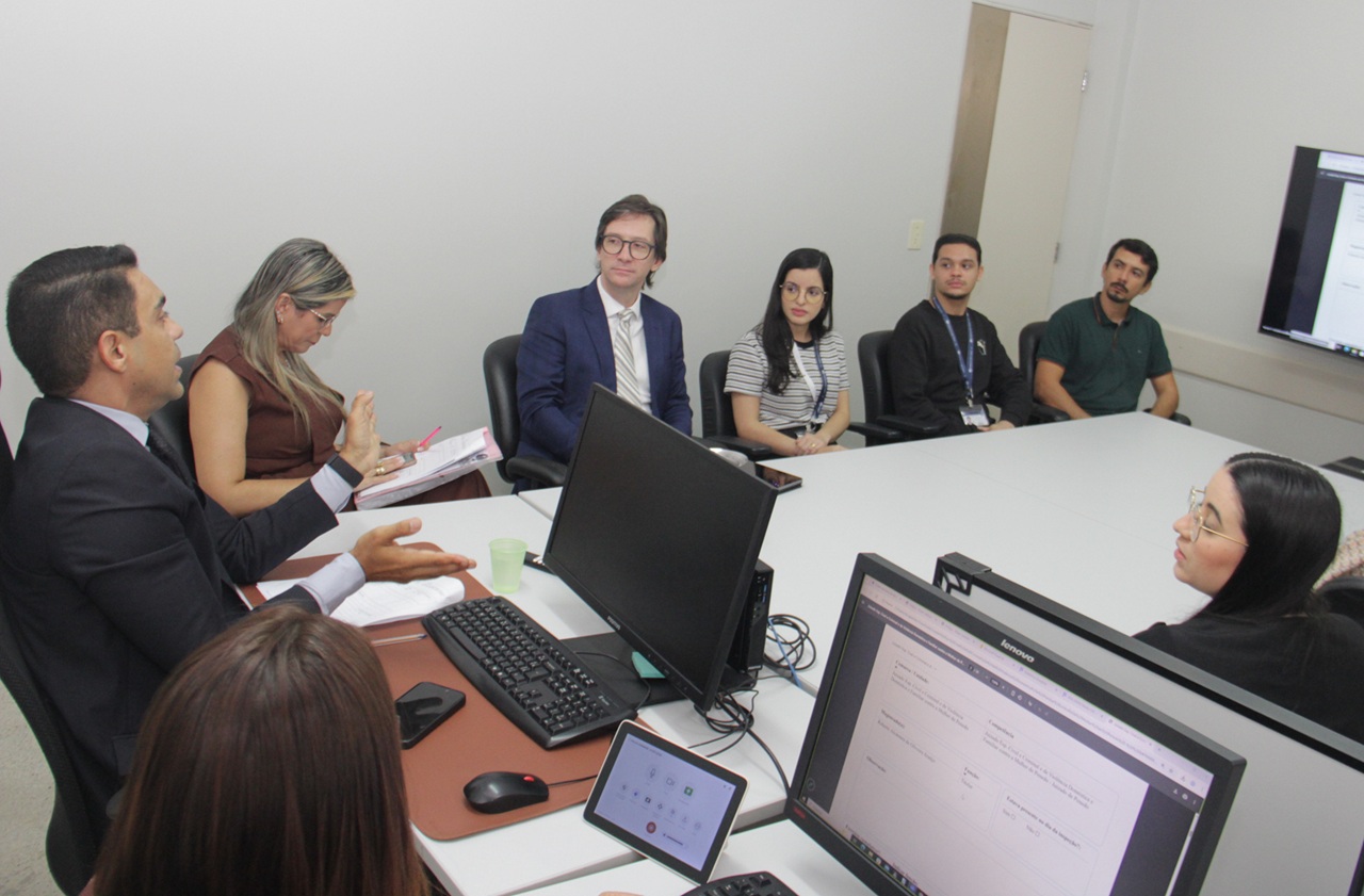 Juiz Geneir Marques, em diálogo com o magistrado Roberto Alcântara e servidores. Foto
